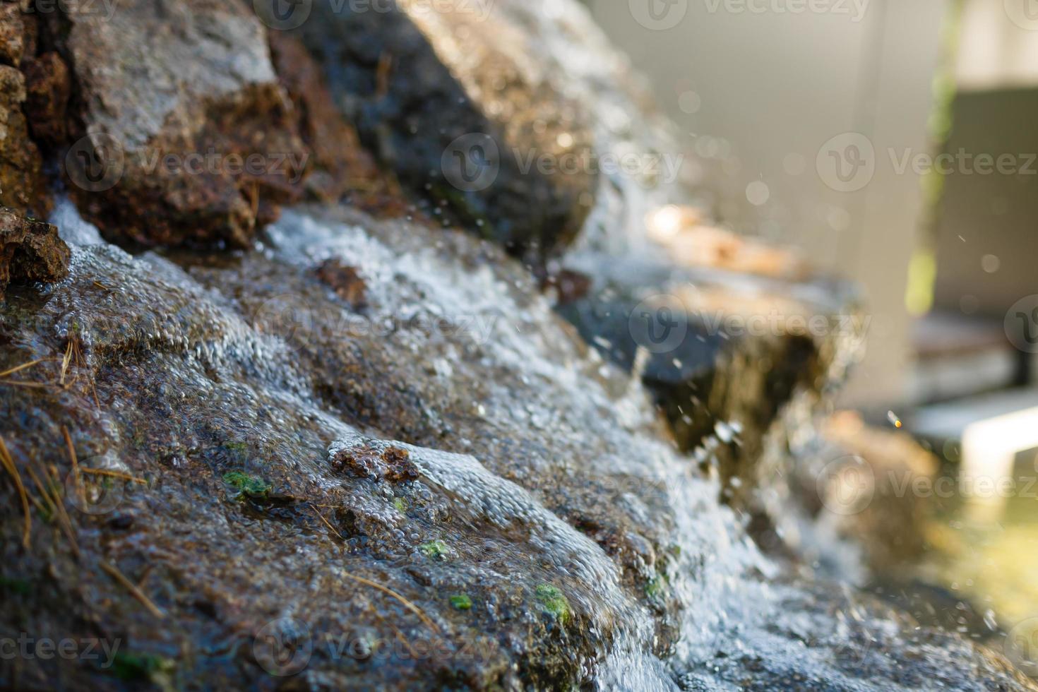dichtbij omhoog van water spatten Aan rotsen van een waterval foto