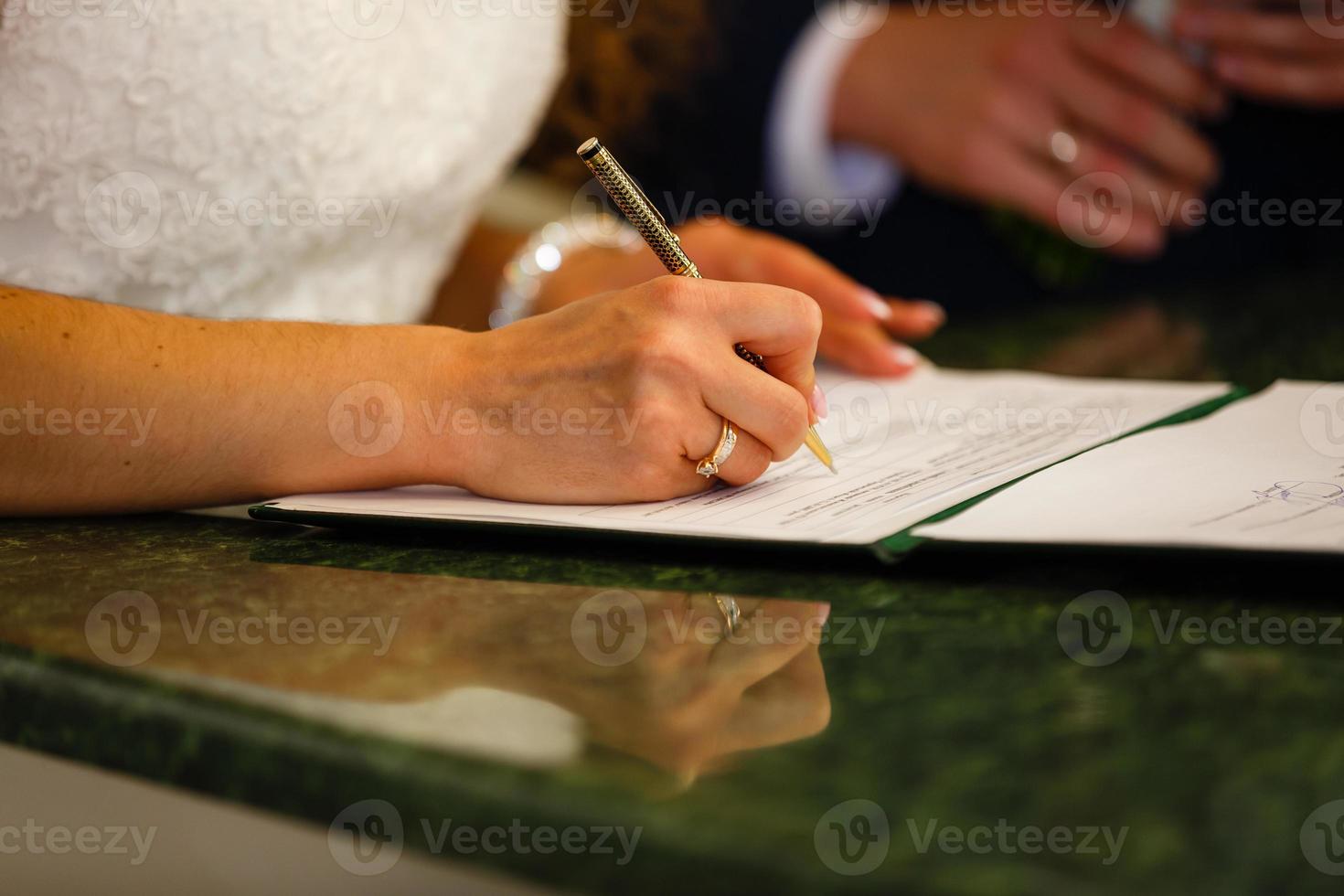 de bruid schrijft met een pen, detailopname van vrouw hand- schrijven Aan papier foto