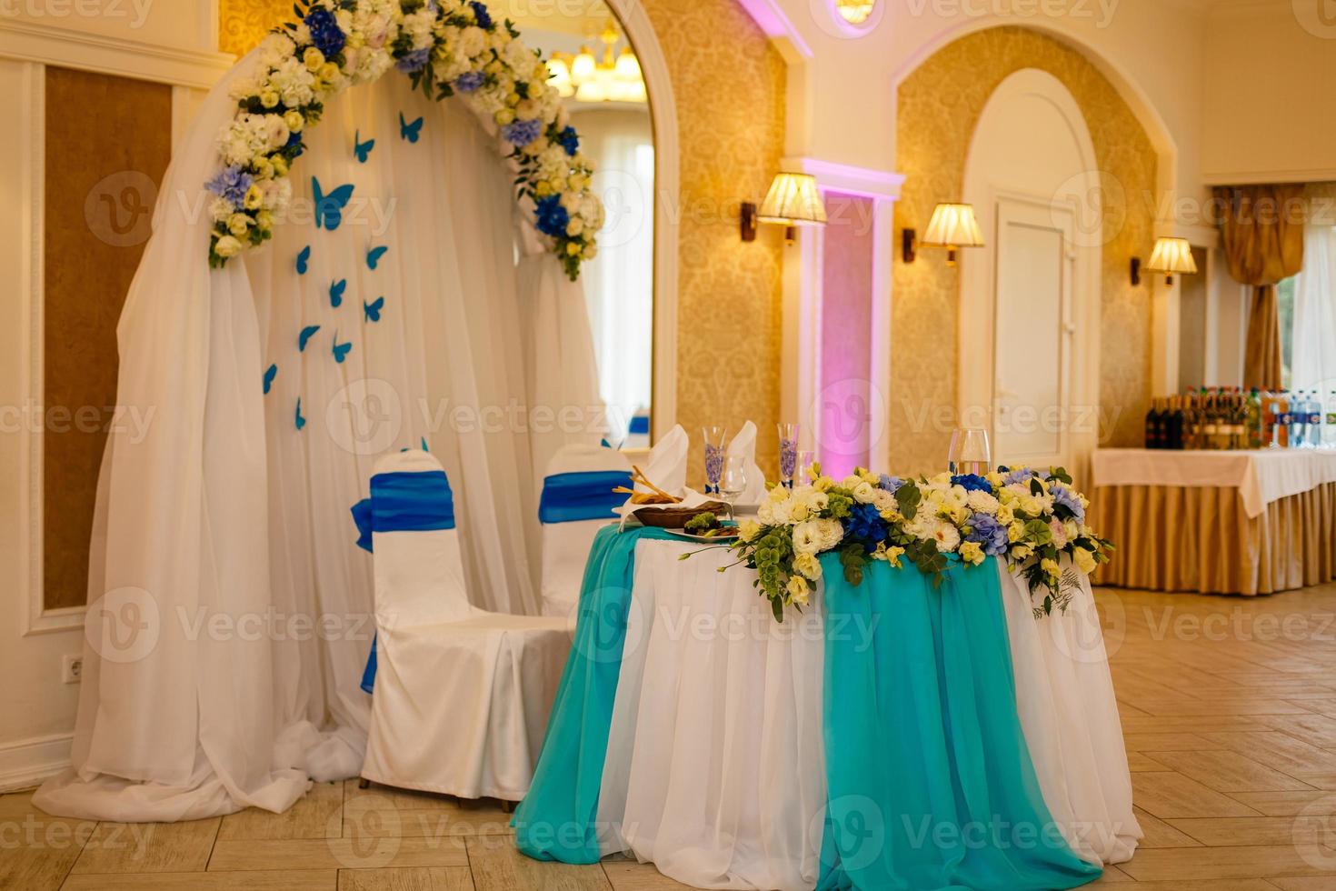 bruiloft decoratie van tafel en stoelen van bruid en bruidegom met bloemen en tule foto