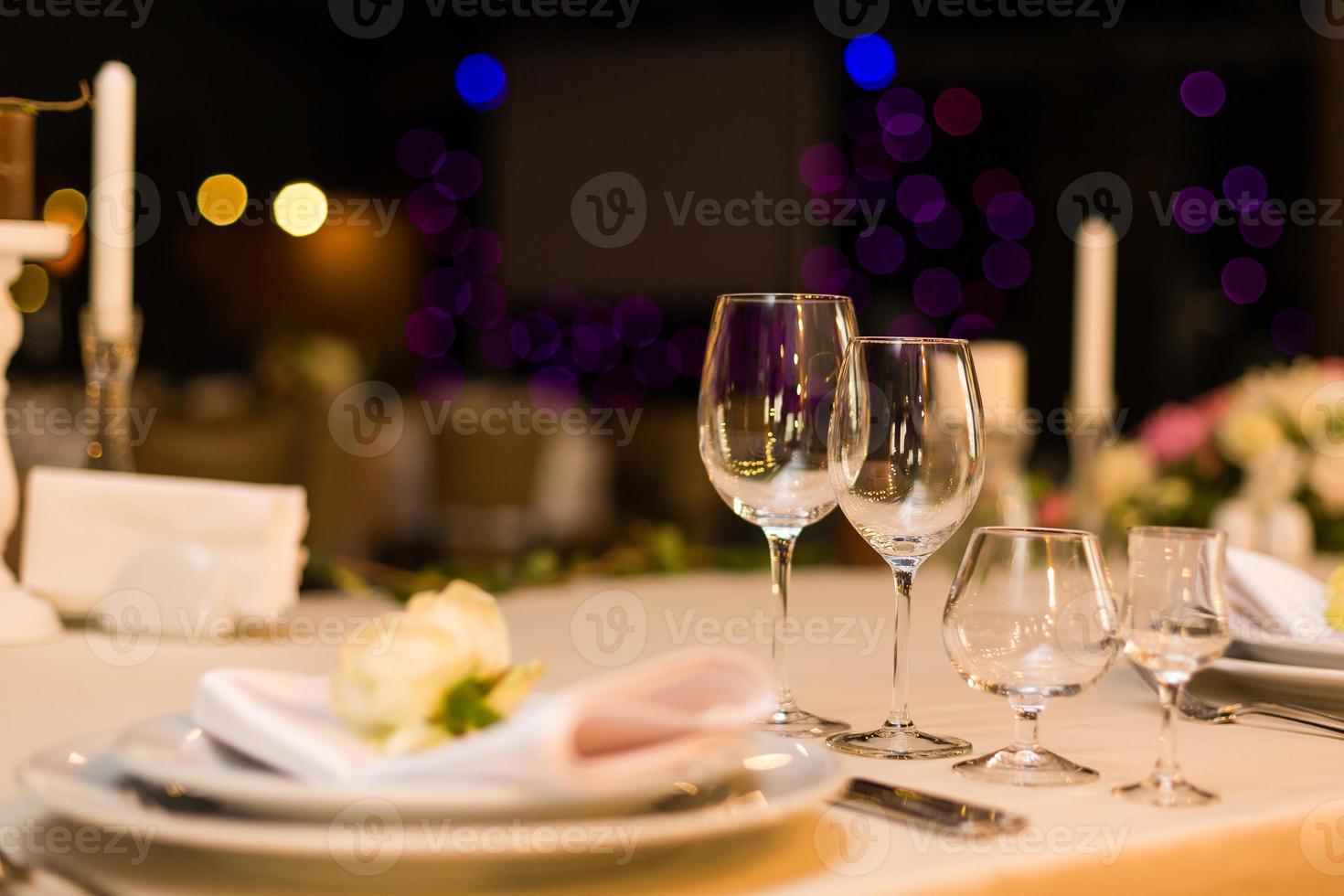mooi tafel instelling met serviesgoed en bloemen voor een partij, bruiloft ontvangst of andere feestelijk evenement. glaswerk en bestek voor verzorgd evenement diner. foto