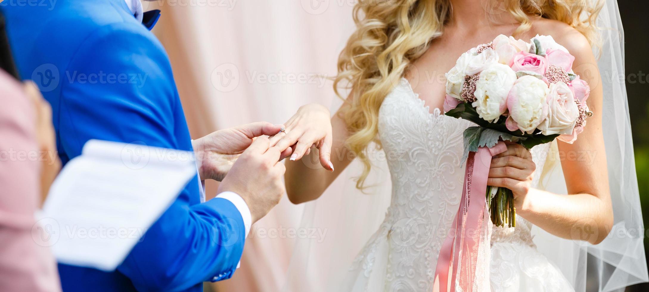 de bruid en bruidegom uitwisseling ringen gedurende een bruiloft ceremonie, een bruiloft in de zomer tuin foto