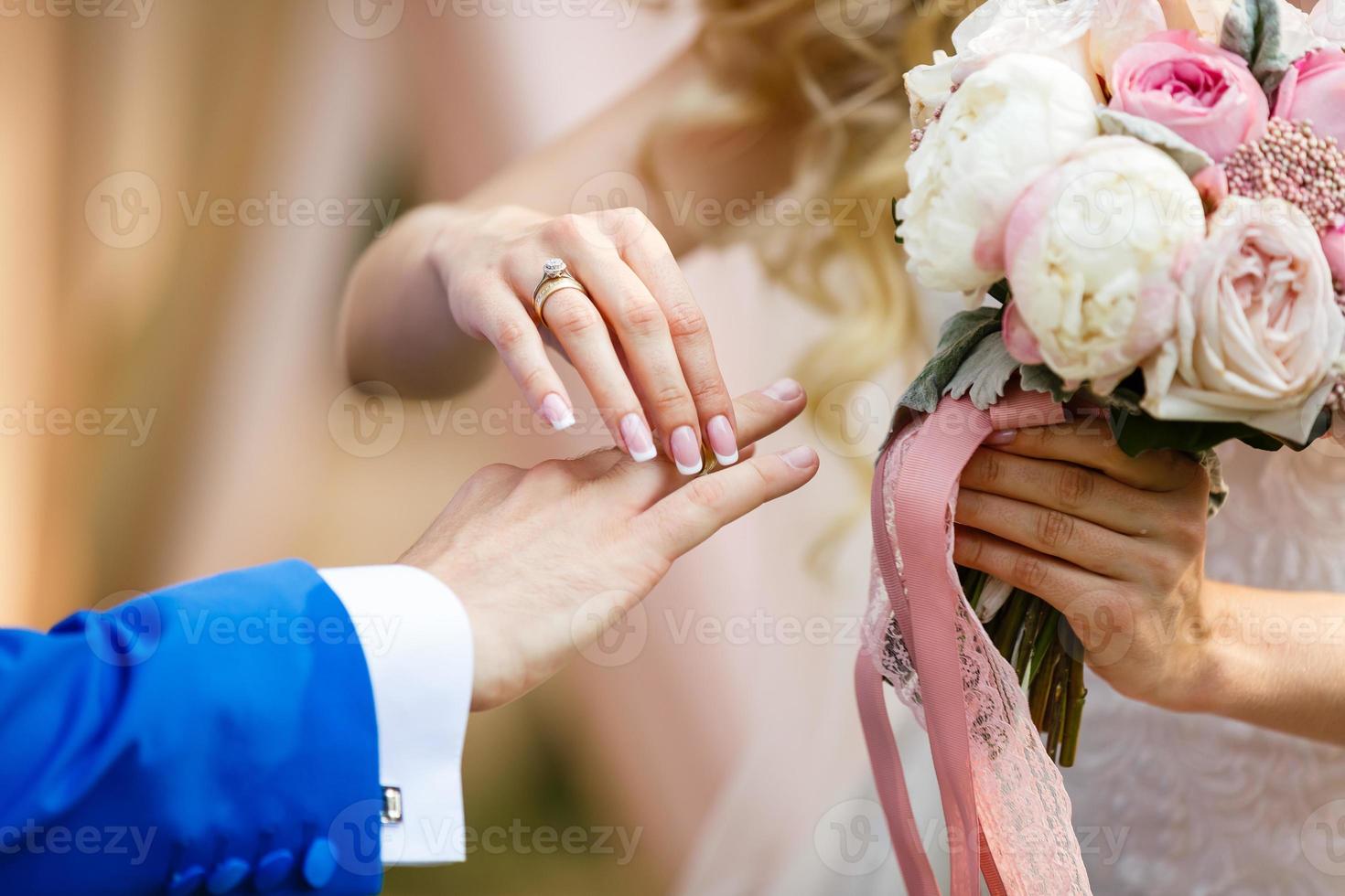 de bruid en bruidegom uitwisseling ringen gedurende een bruiloft ceremonie, een bruiloft in de zomer tuin foto