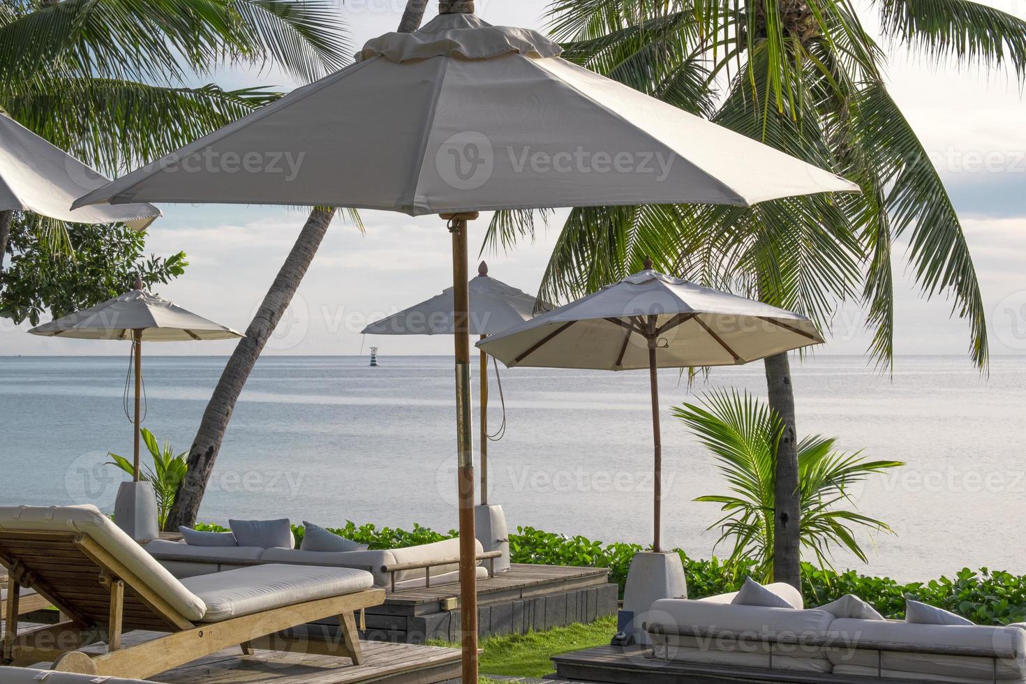 ontspannende zon bed houdende warm weer in zomer vakantie Bij zee strand hua hin Thailand. groot paraplu wit kleur beschermen uv van zon licht. foto