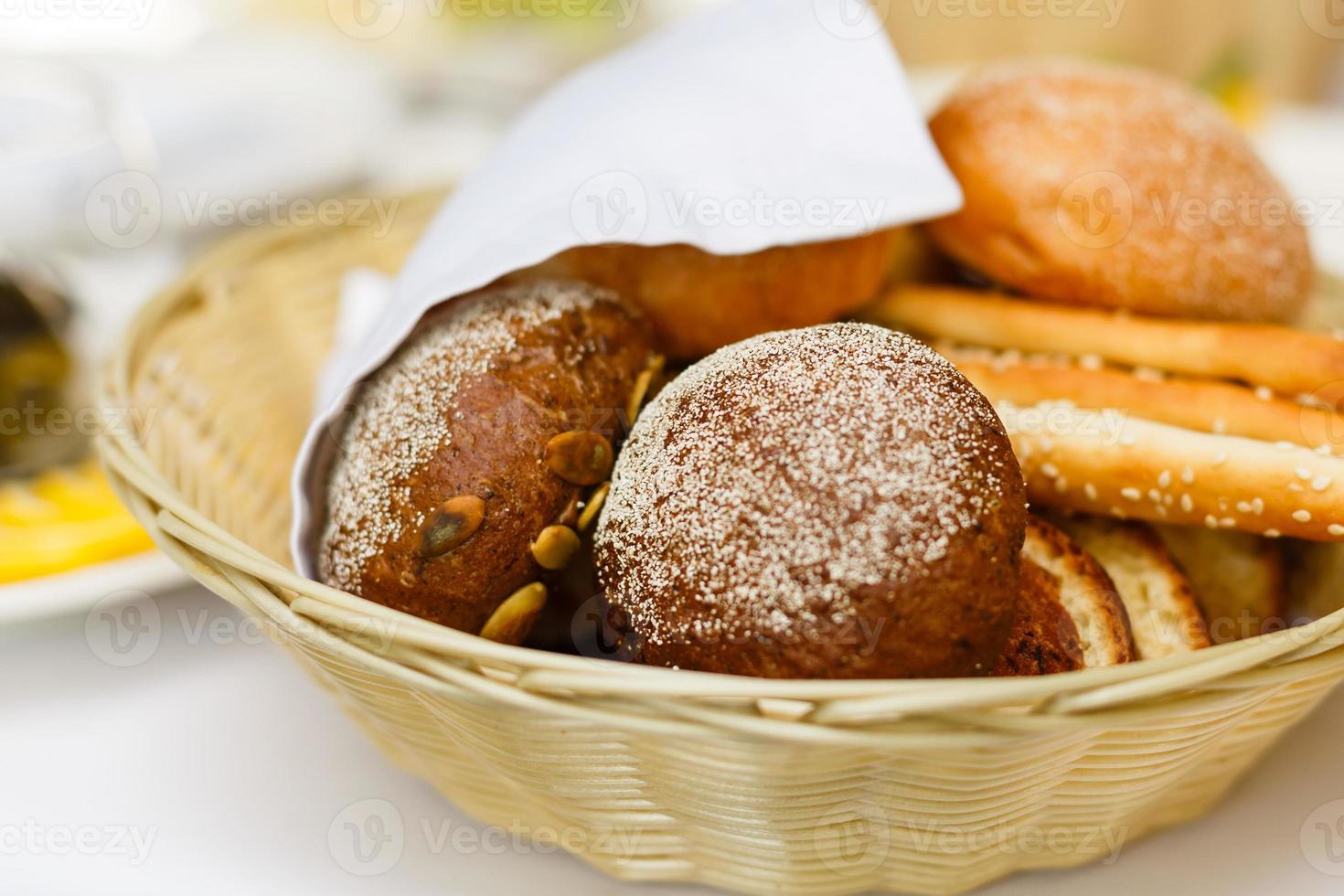 brood in mand met boter onder zonlicht broodjes brood in een mand tafel foto