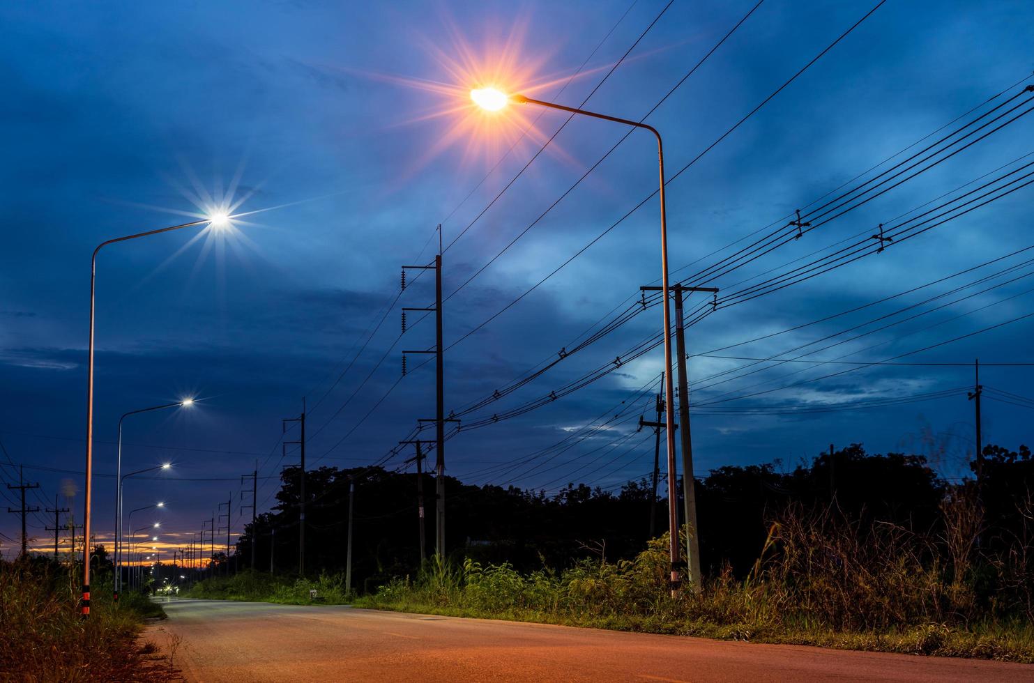 een mooi sterrenlicht landschap visie van oranje en wit lantaarns naast een land weg,. foto