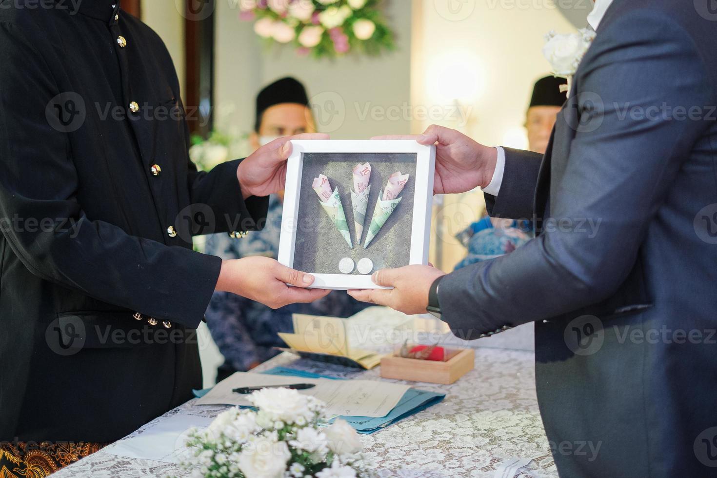 twee mannen Holding bruiloft geschenk doos in een traditioneel bruiloft ceremonie in Indonesië foto