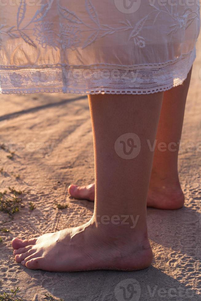 dichtbij omhoog vrouw kaal voeten staand Aan zand concept foto