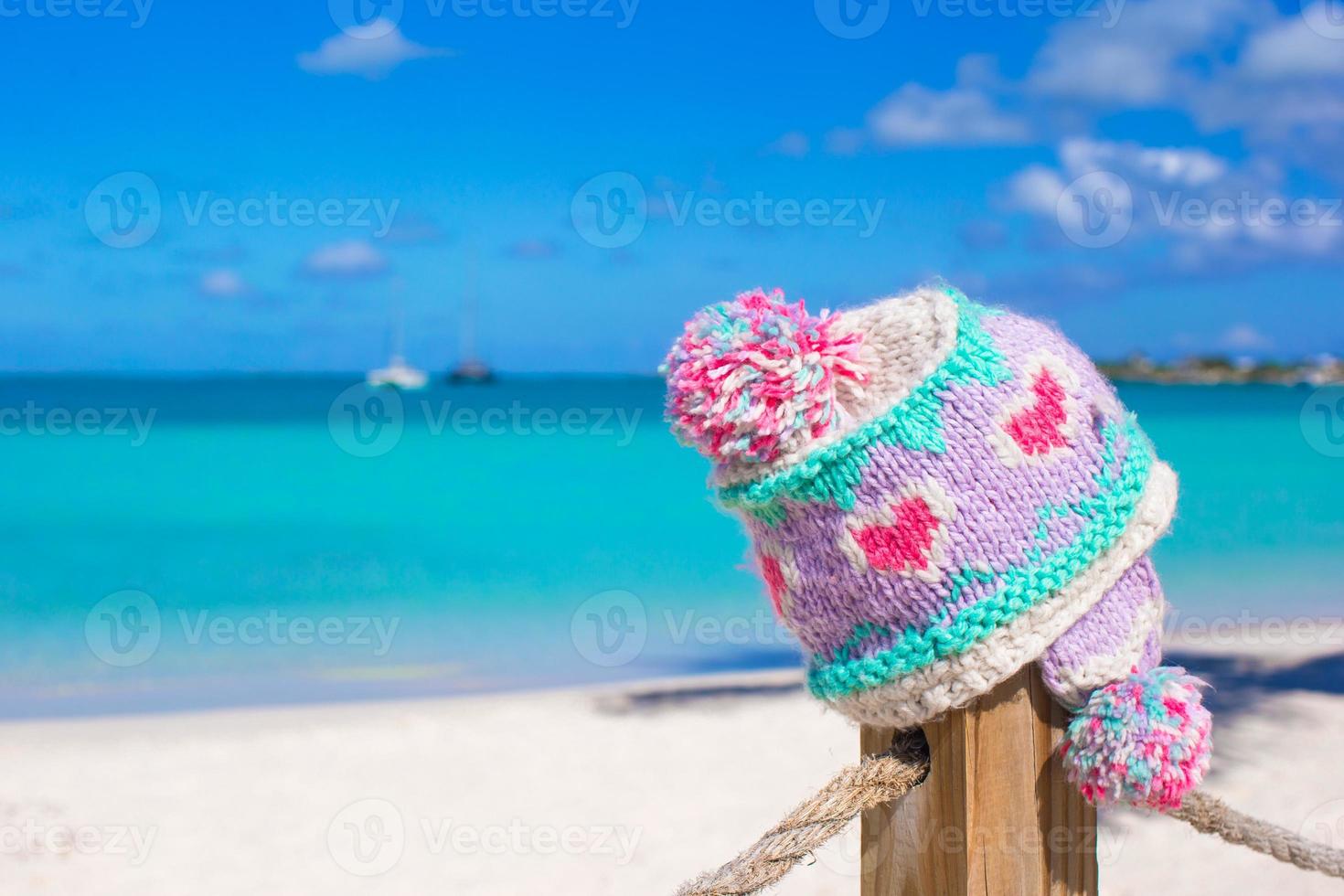 detailopname warm gebreid pet Aan hek Bij tropisch strand foto