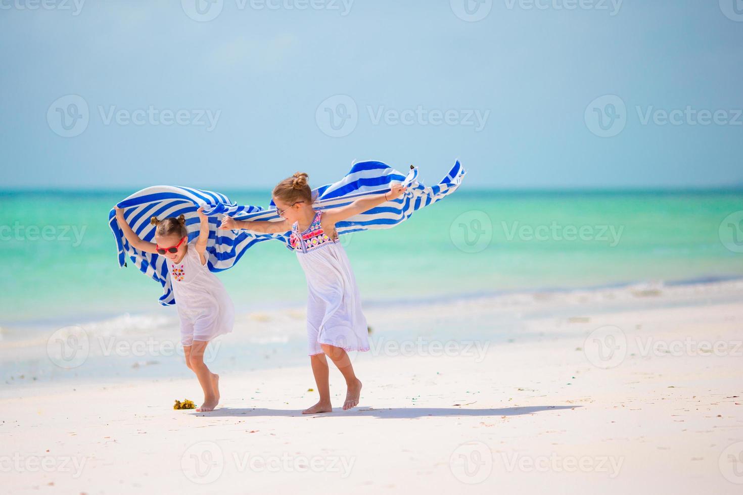 schattige kleine meisjes op het strand tijdens de zomervakantie foto