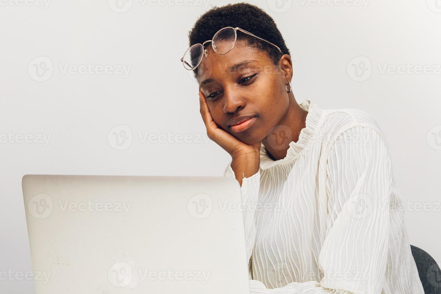 zwart vrouw gebruik makend van een laptop Bij kantoor foto