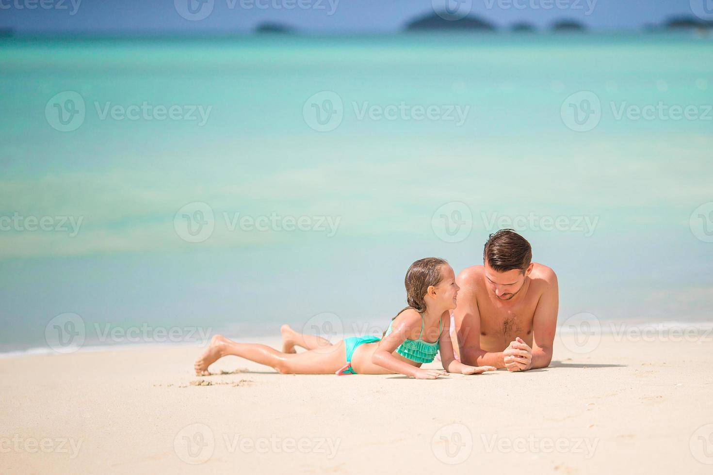 weinig meisje en gelukkig vader hebben pret gedurende strand vakantie foto