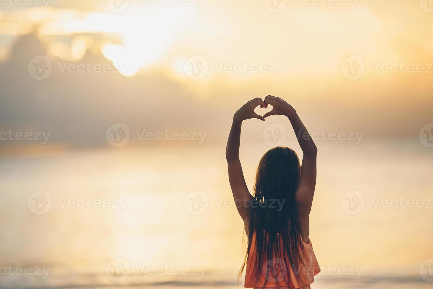silhouet van hart gemaakt door kinderen hand- Bij zonsondergang foto