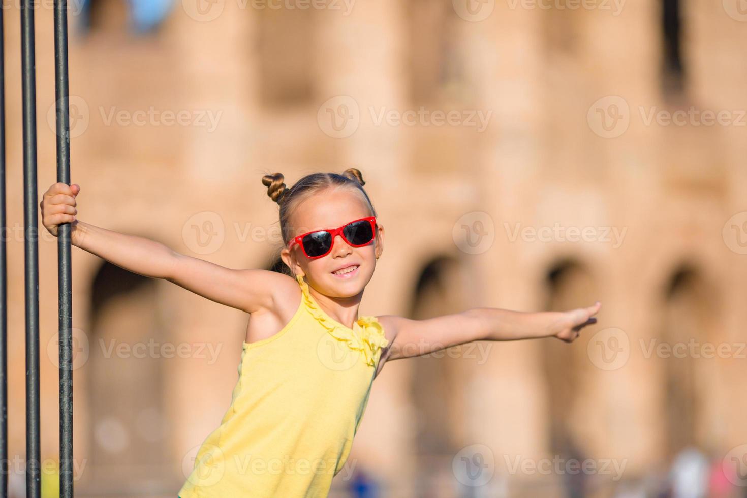 aanbiddelijk weinig actief meisje hebben pret in voorkant van colosseum in Rome, Italië. kind uitgeven kinderjaren in Europa foto