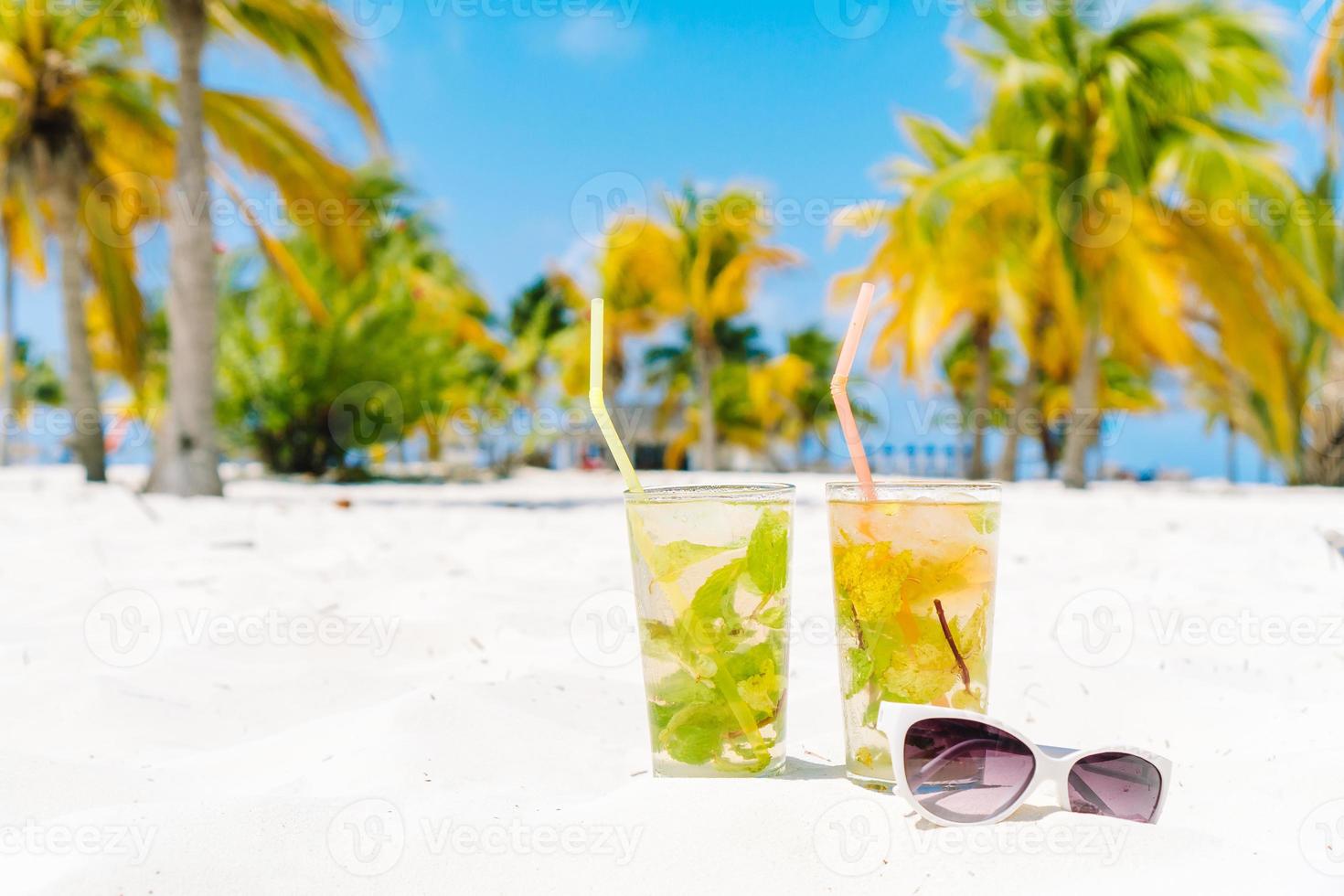 twee verkoudheid smakelijk mohito cocktails Aan de wit zanderig strand in palm bosje foto