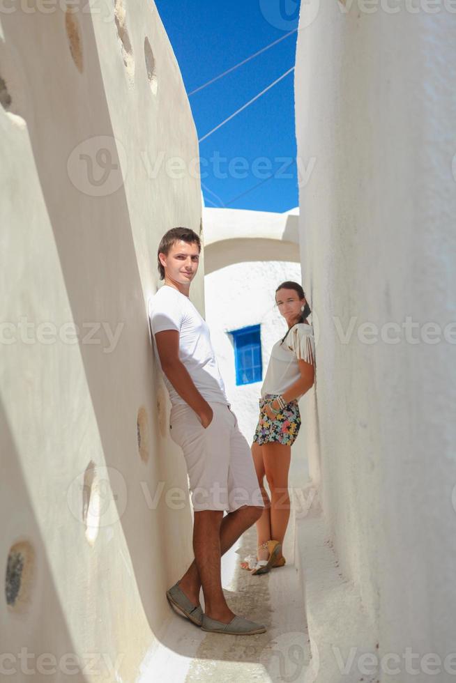 jong paar in liefde wandelen Aan versmallen straten van de dorp emporio, santorini, Griekenland foto