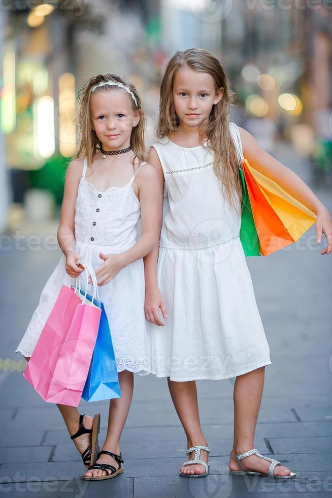 mooi glimlachen weinig meisjes met boodschappen doen Tassen foto