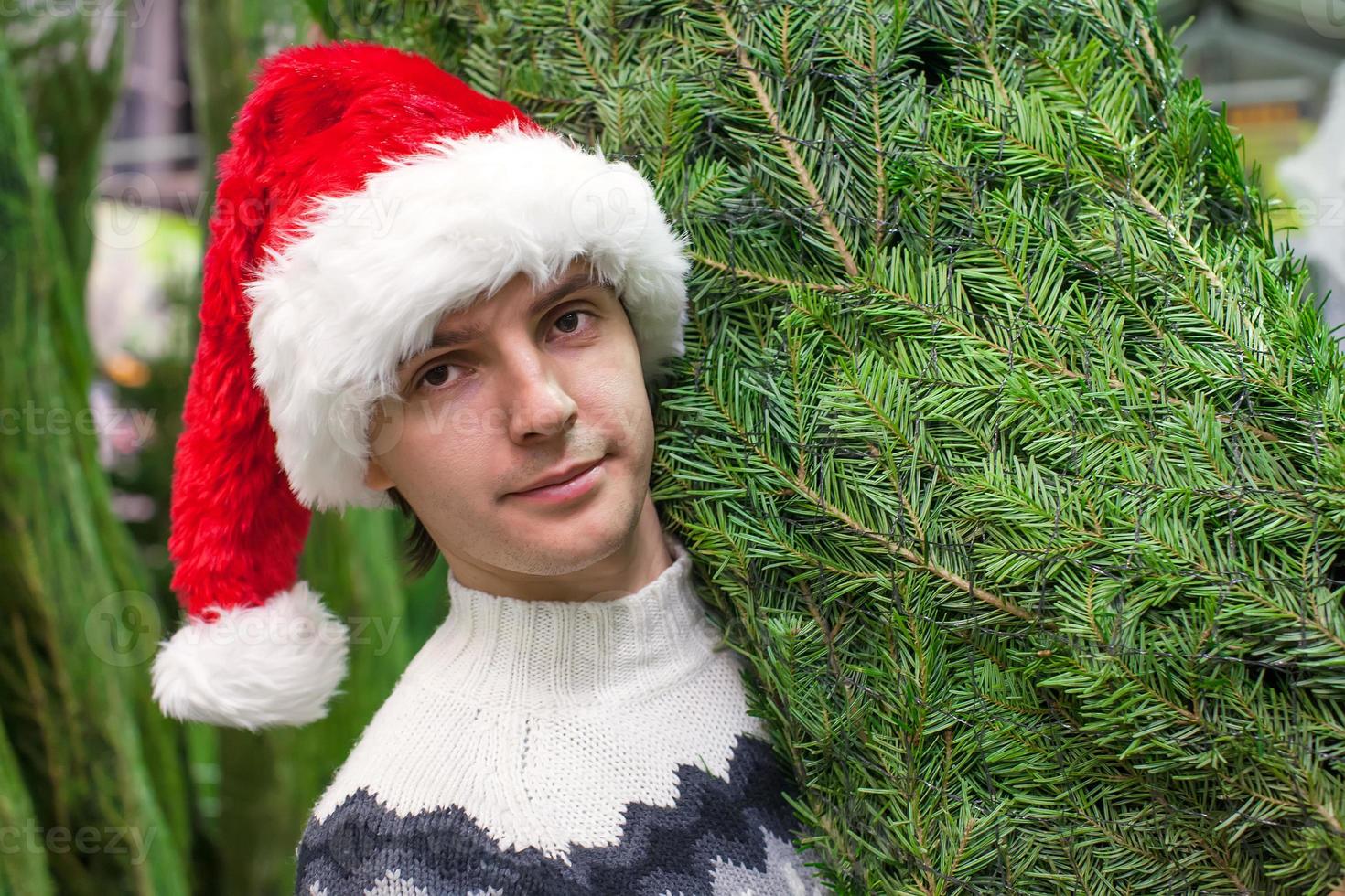 detailopname jong Mens buying een Kerstmis boom in de op te slaan foto