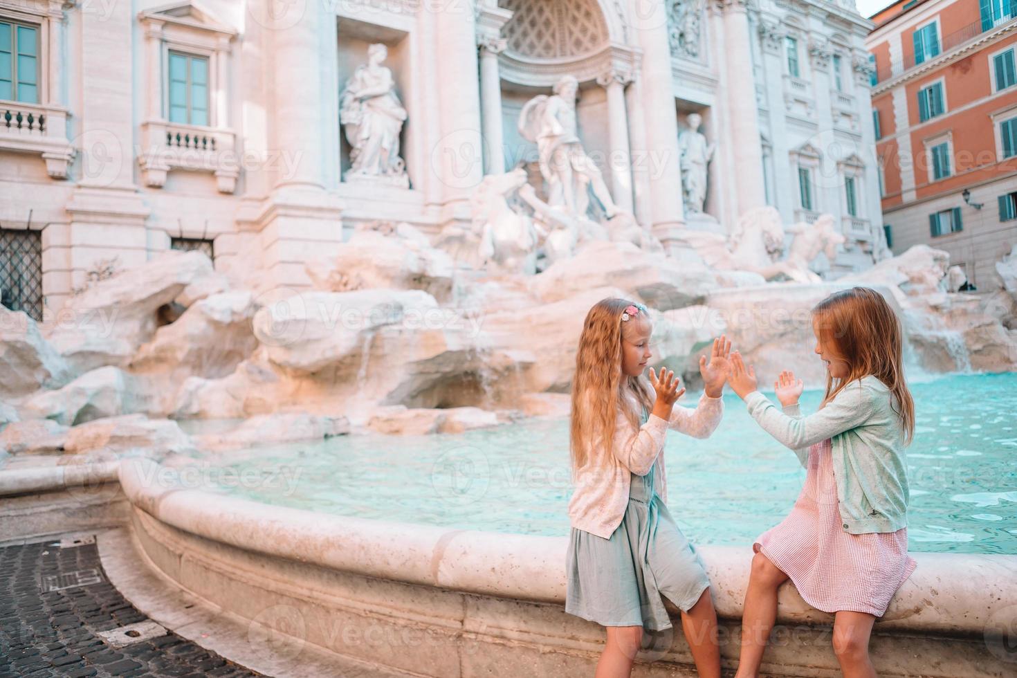 aanbiddelijk weinig meisjes in de buurt de fontein van Trevi in Rome. foto