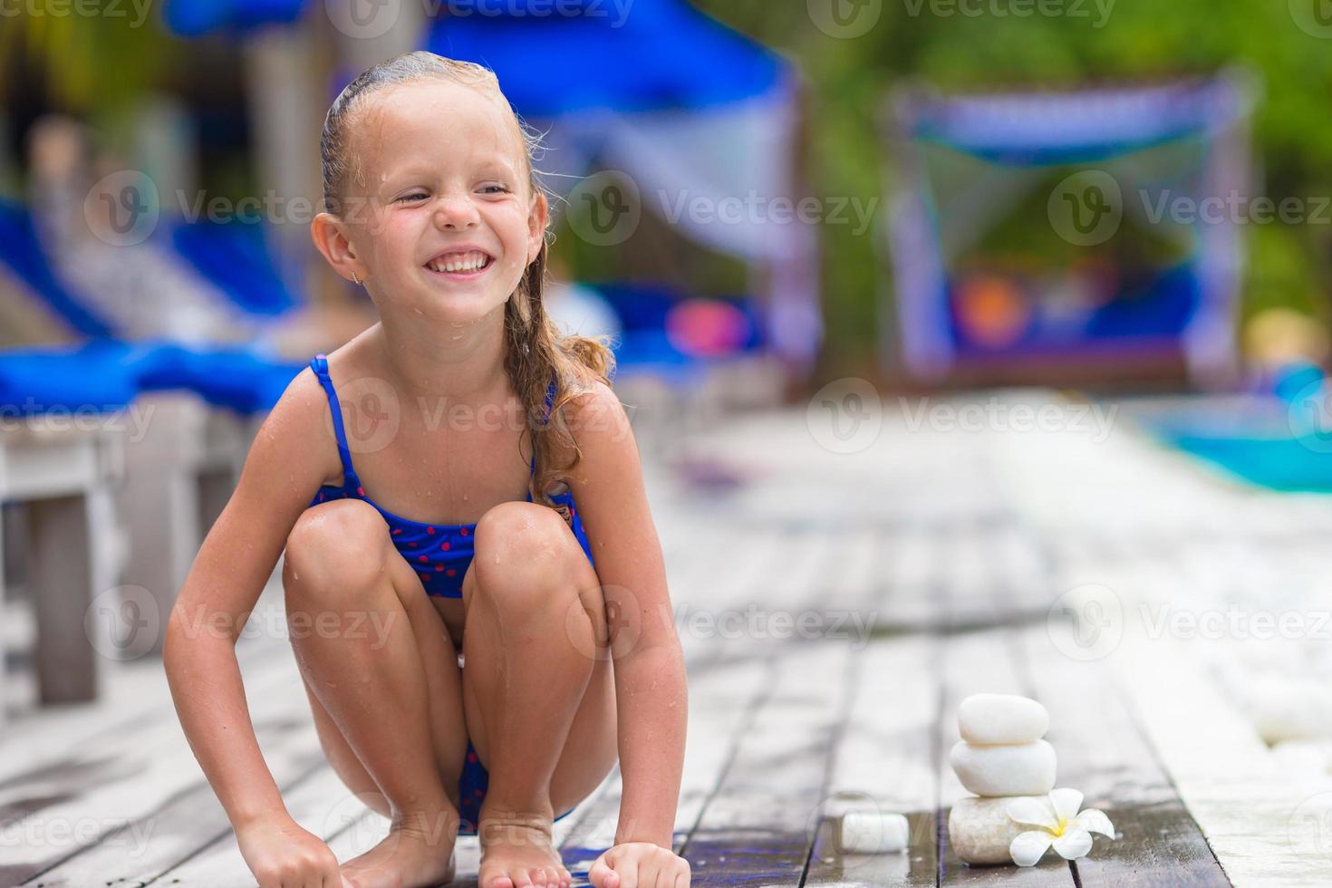 aanbiddelijk gelukkig meisje in de buurt zwemmen zwembad foto