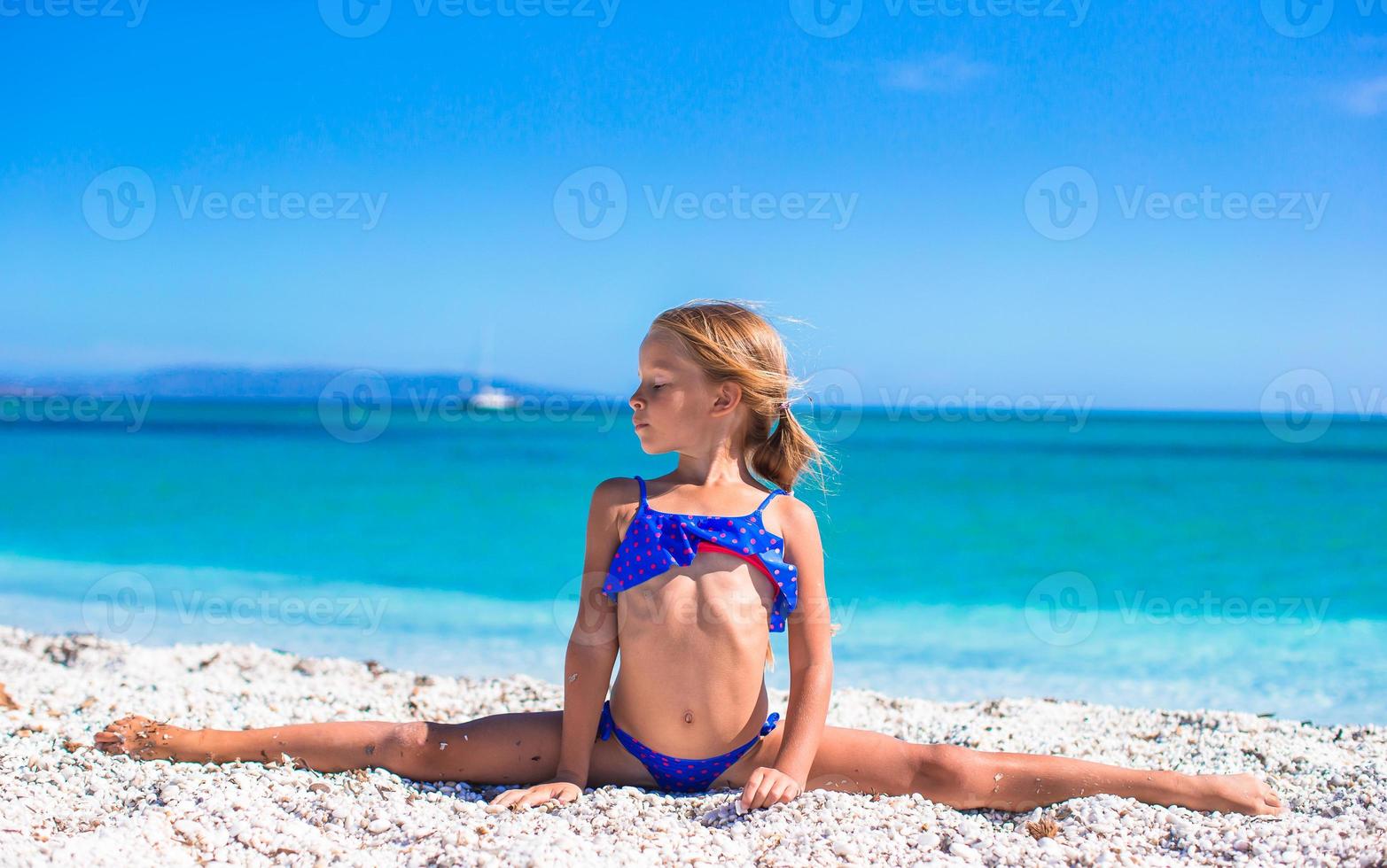 weinig meisje maken been-split Aan tropisch wit zanderig strand foto