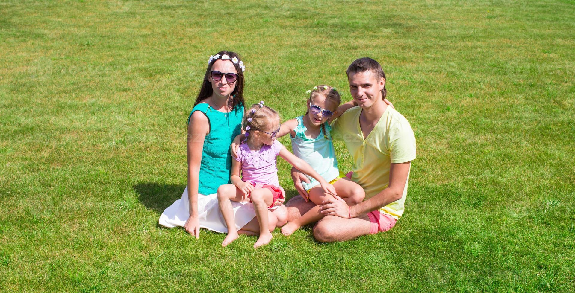 gelukkig familie met twee kinderen buitenshuis Aan zomer dag foto