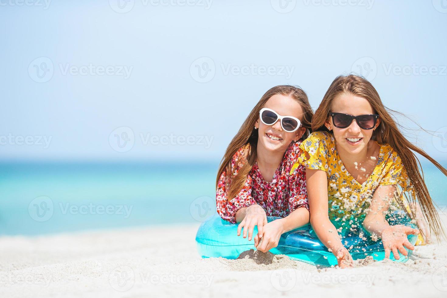 weinig gelukkig grappig meisjes hebben een veel van pret Bij tropisch strand spelen samen. foto