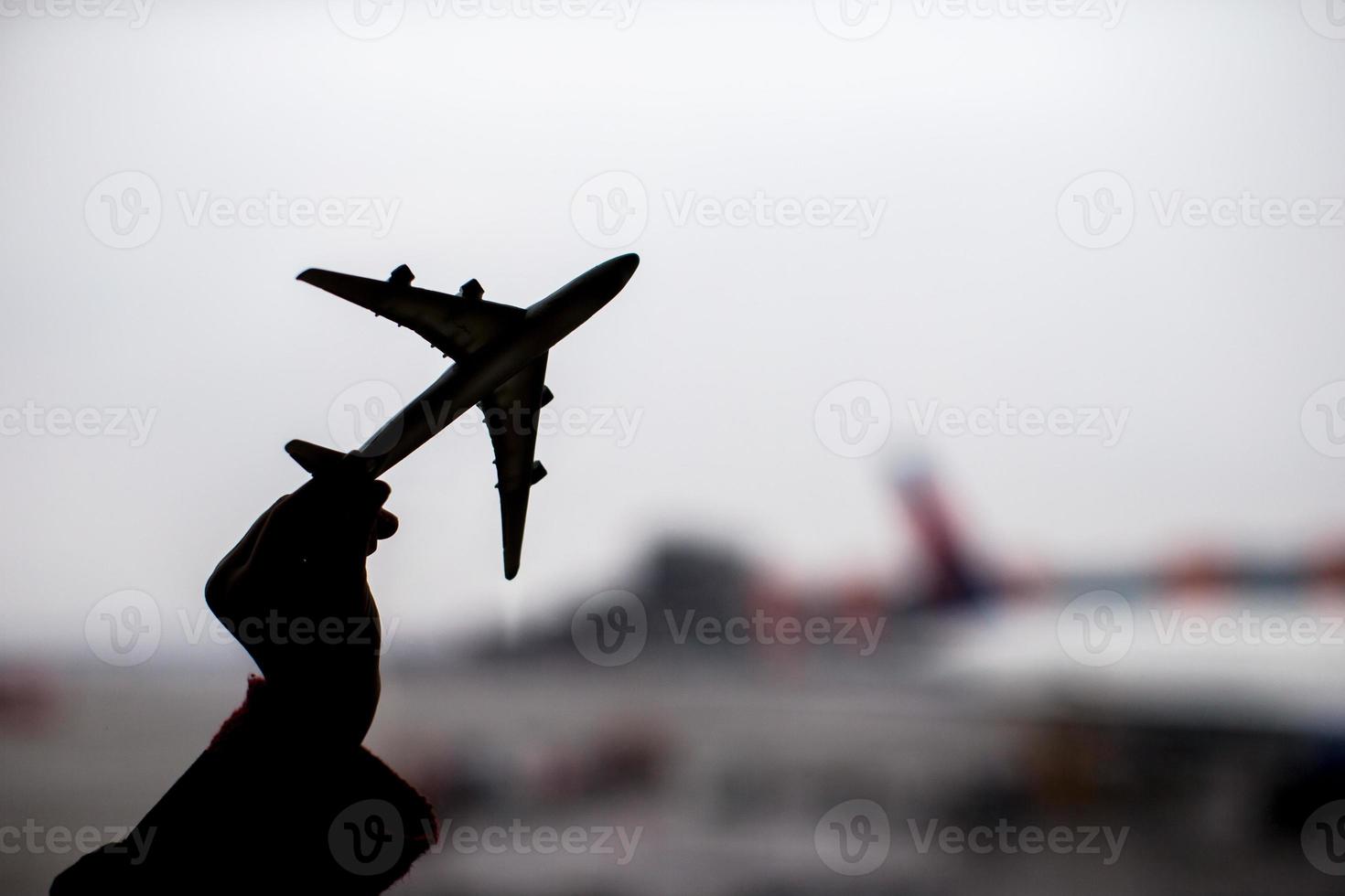 silhouet van een klein vliegtuigmodel op luchthavenachtergrond foto