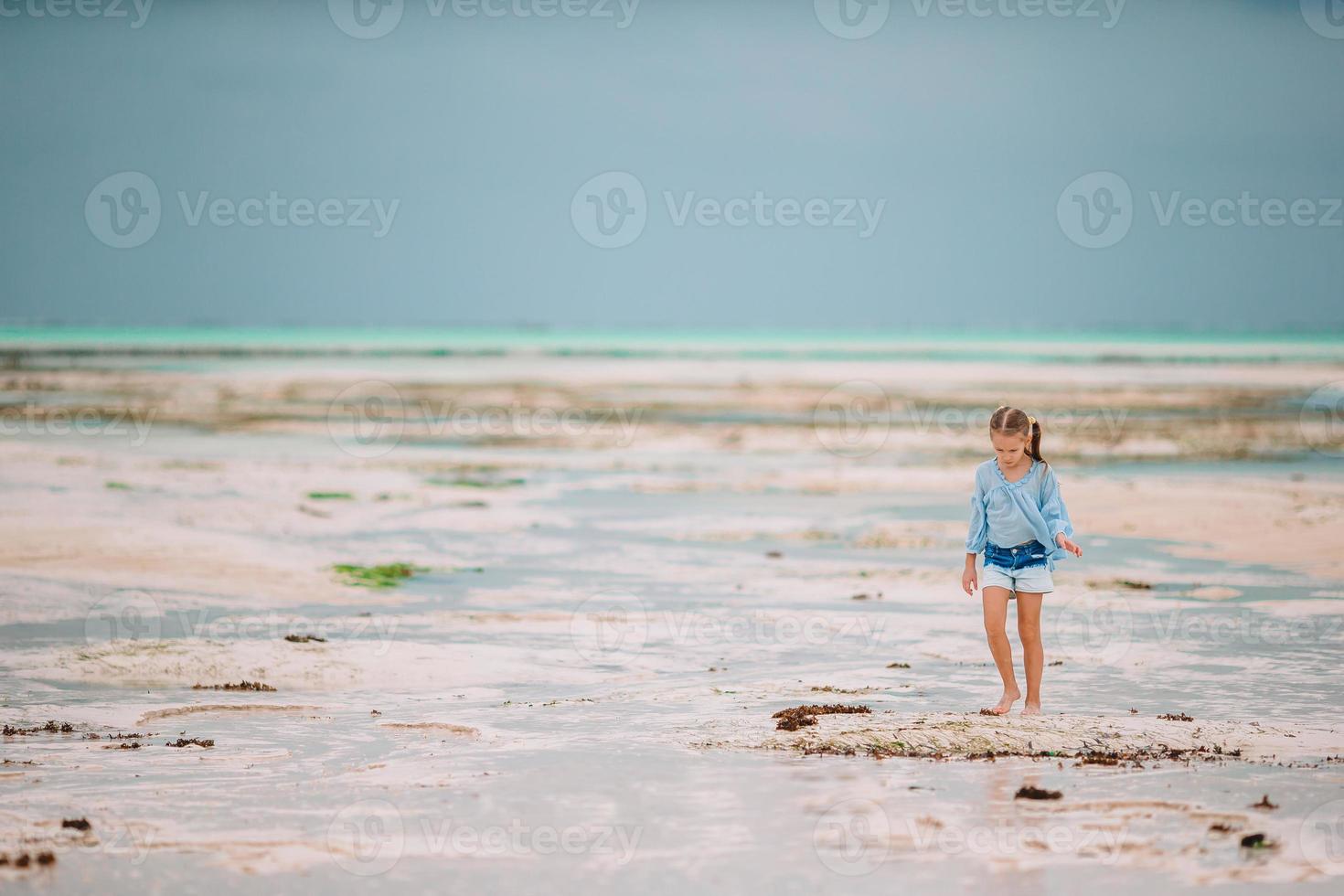 schattig klein meisje op het strand tijdens de zomervakantie foto