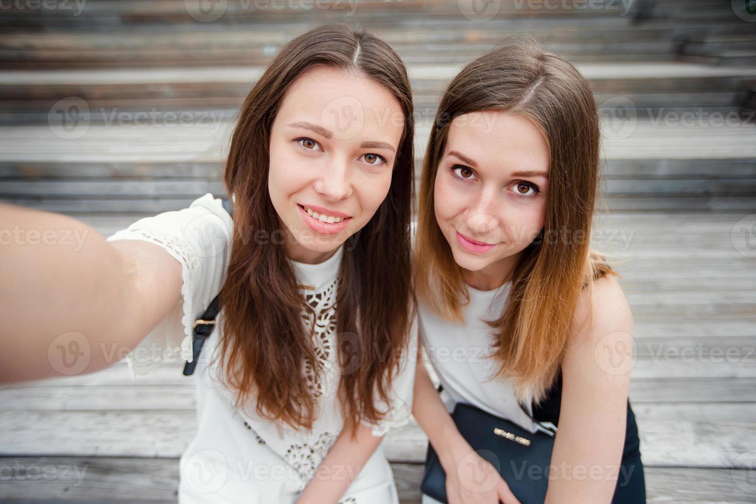 portret van Kaukasisch mooi meisjes maken selfie buitenshuis. jong toerist vrienden op reis Aan vakantie glimlachen gelukkig. foto