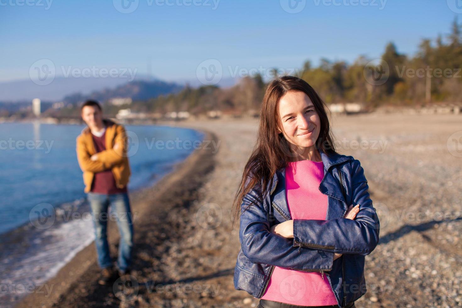 detailopname van gelukkig vrouw Aan een achtergrond de jong Mens Bij leeg strand foto