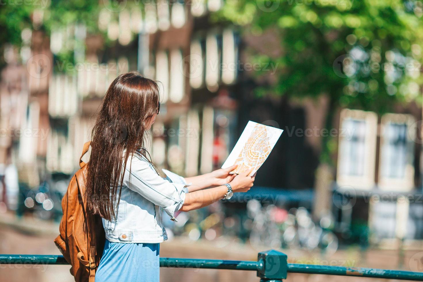gelukkig jong vrouw met een stad kaart Aan fiets in Europese stad foto