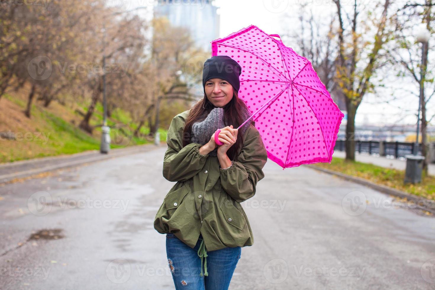 jong vrouw wandelen met paraplu in herfst regenachtig dag foto