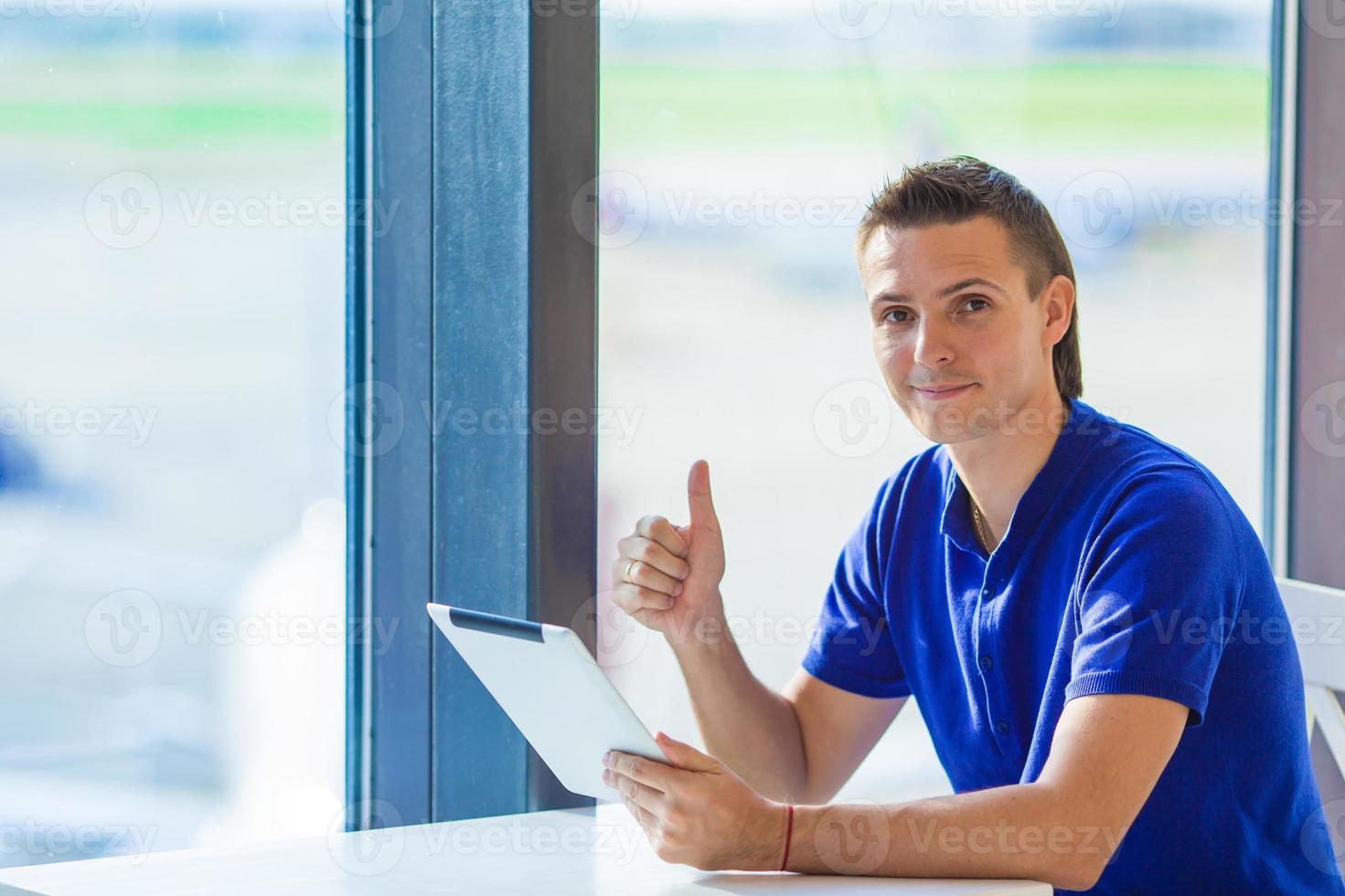 jong zakenman werken met laptop Bij luchthaven cafe w foto