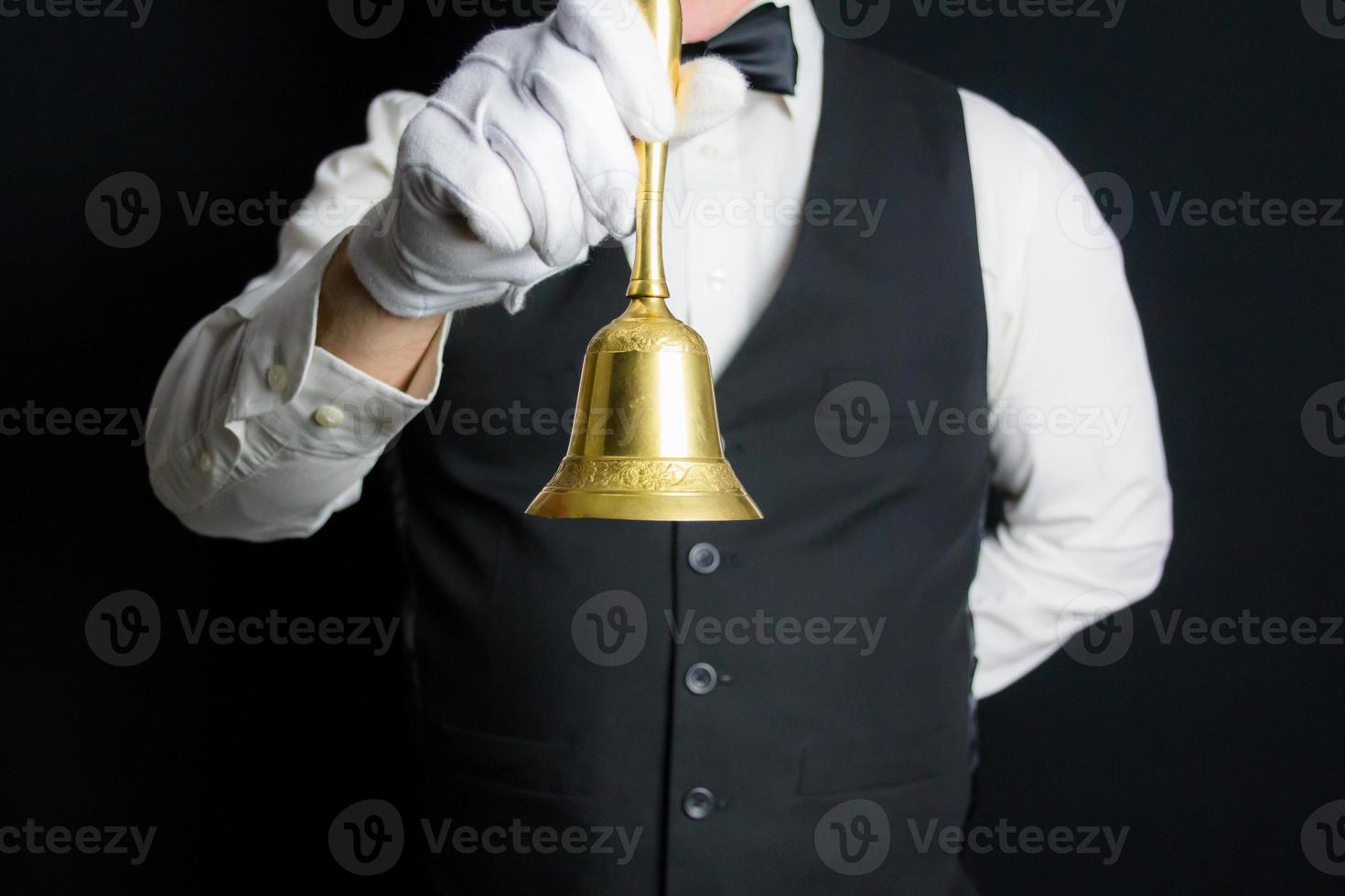 portret van butler of ober in zwart hesje en wit handschoenen Holding goud klok. concept van onderhoud industrie en professioneel beleefdheid. ring voor onderhoud. foto
