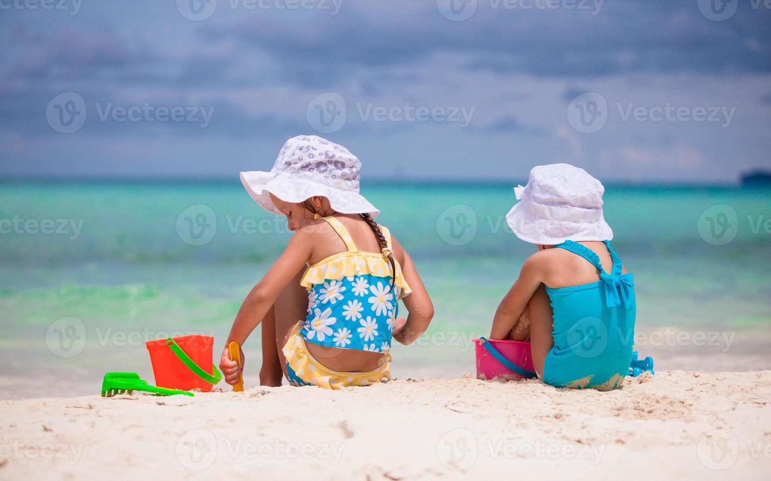 kleine meisjes spelen met strandspeelgoed tijdens tropische vakantie foto