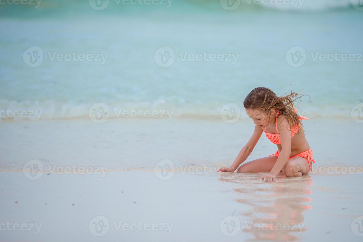 weinig kind spelen Aan wit strand foto