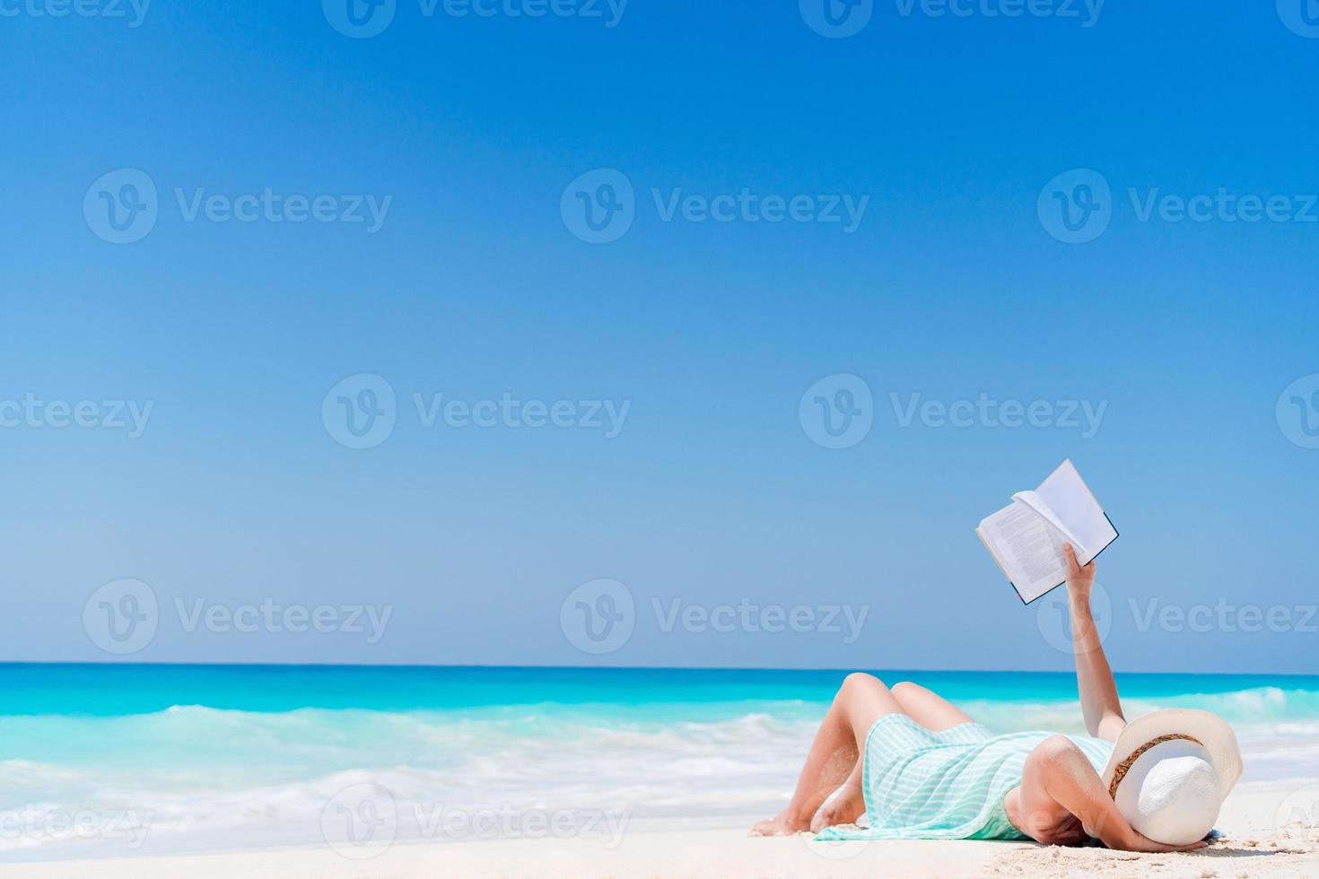 jong vrouw lezing boek gedurende tropisch wit strand foto