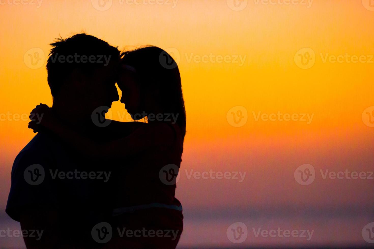 familie silhouet in de zonsondergang Bij de strand foto