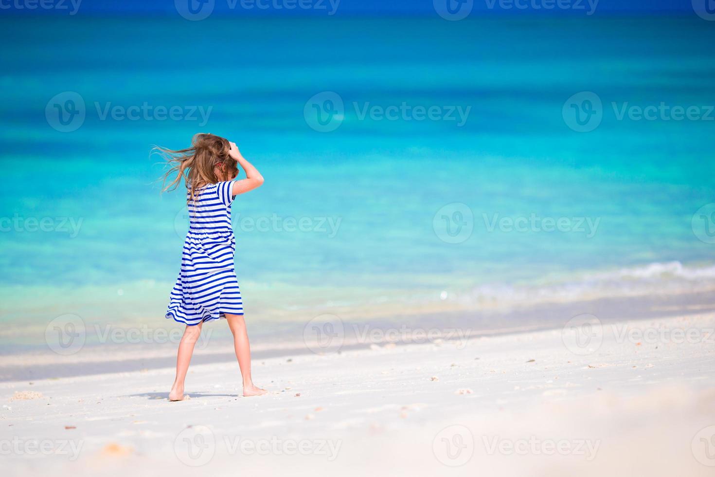schattig klein meisje op het strand tijdens de zomervakantie foto