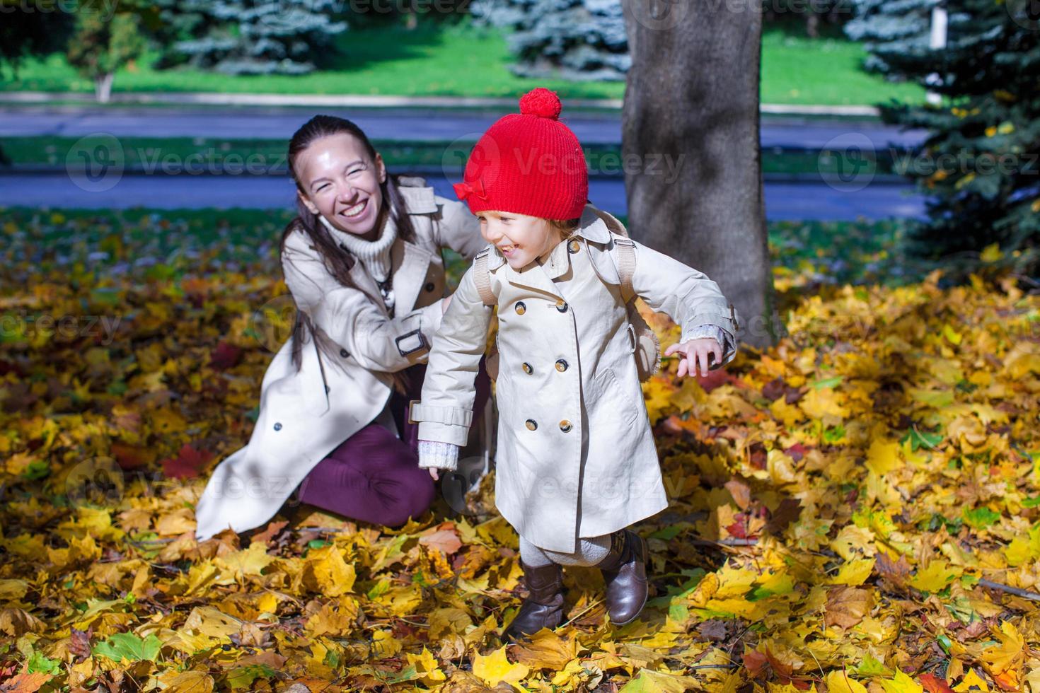 mode jong moeder en haar aanbiddelijk weinig dochter hebben pret in zonnig herfst dag foto