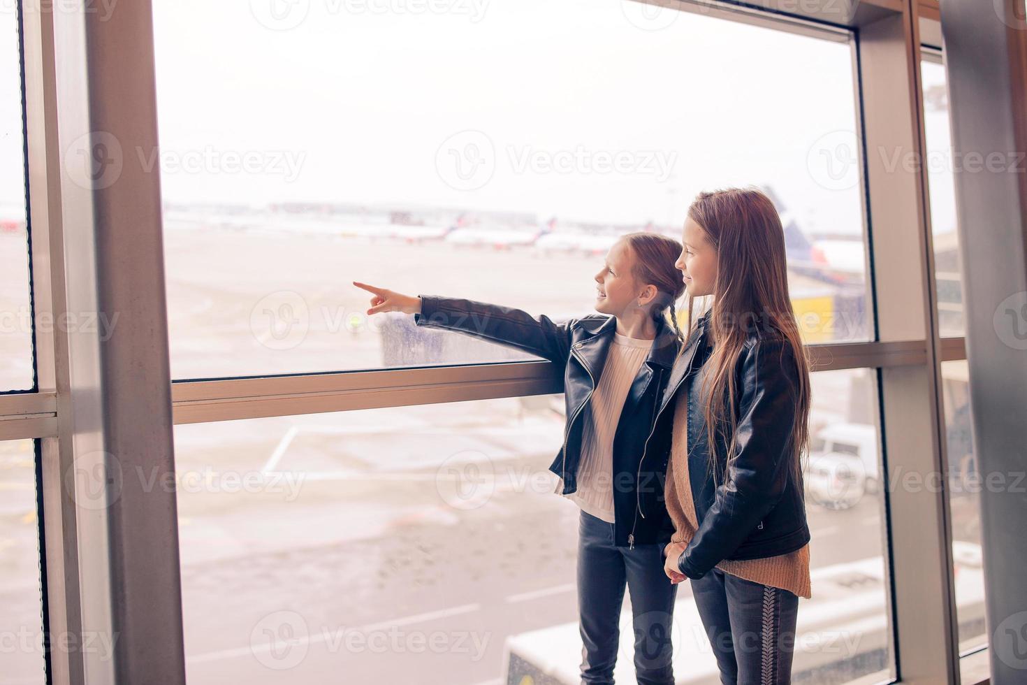 weinig kind in luchthaven aan het wachten voor instappen foto