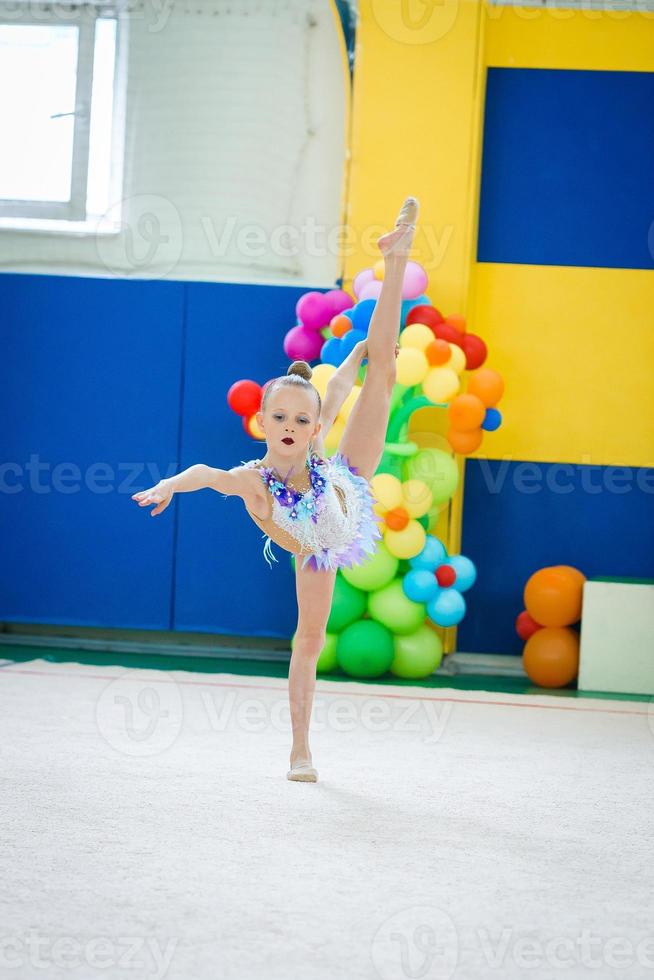 mooi weinig actief gymnast meisje met haar prestatie Aan de tapijt foto