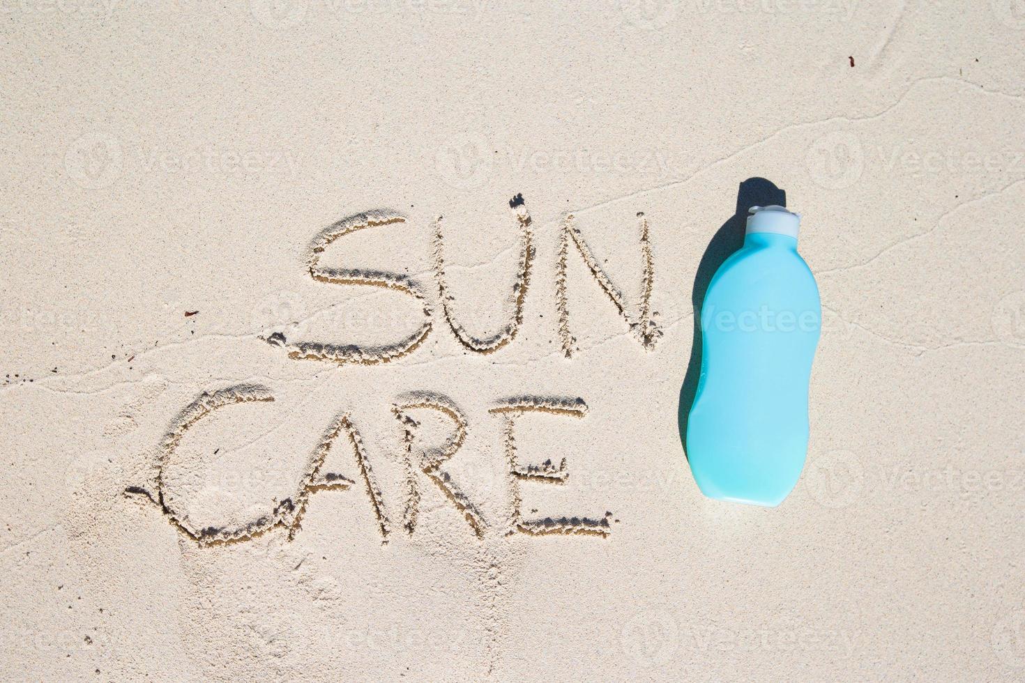 zonnebrand geschreven Aan tropisch wit zand en zonnecreme foto