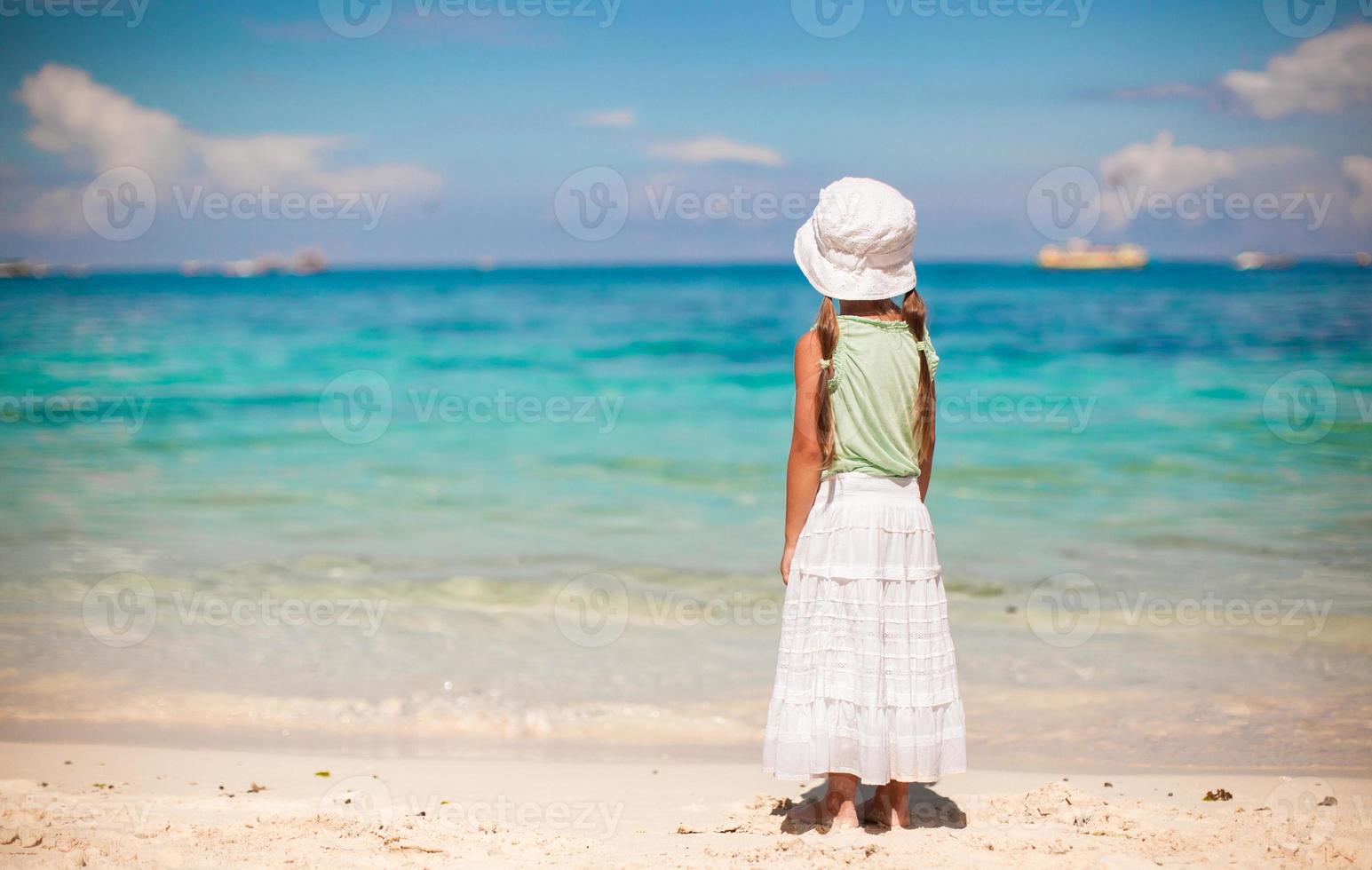 schattig klein meisje lopen op tropisch wit strand foto