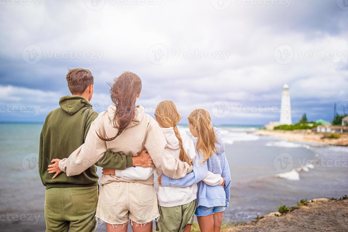 familie van vier wandelen naar de vuurtoren foto