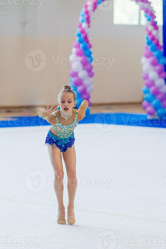 mooi weinig actief gymnast meisje met haar prestatie Aan de tapijt foto