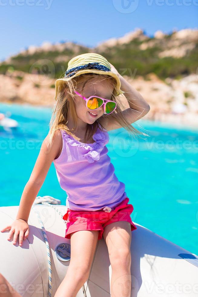 schattig weinig meisje genieten van het zeilen Aan boot gedurende zomer vakantie foto
