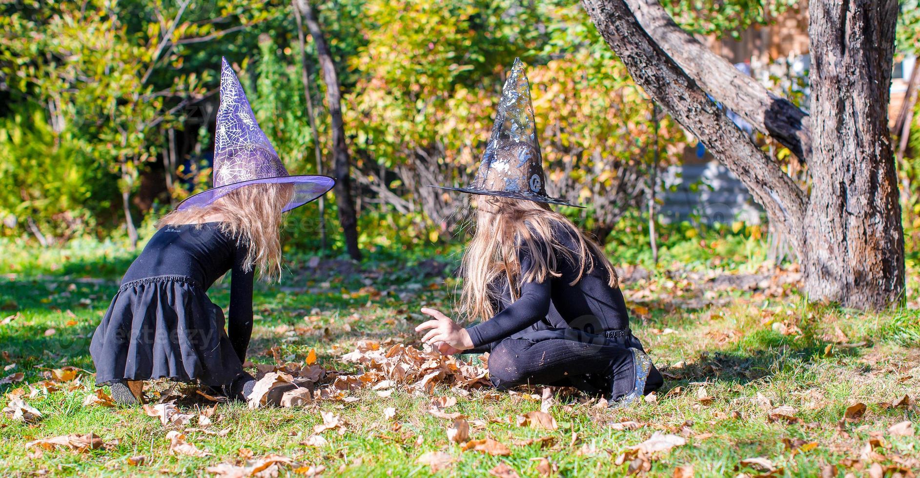 aanbiddelijk weinig meisjes in heks kostuum Aan halloween hebben pret foto