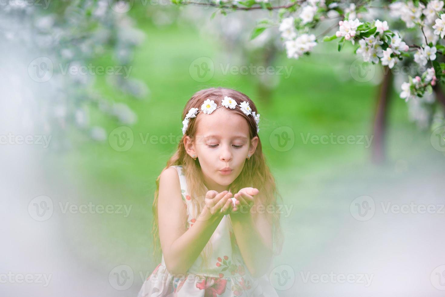 schattig meisje in bloeiend appel boom tuin genieten de warm dag foto