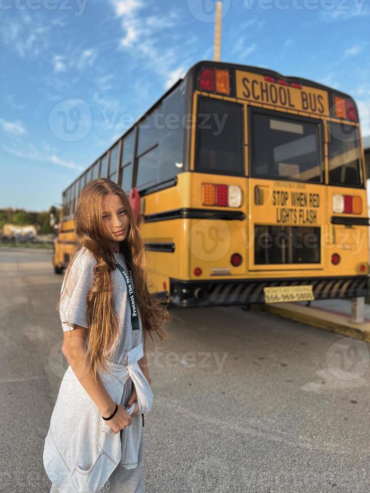 mooi tiener meisje krijgen Aan school- bus foto